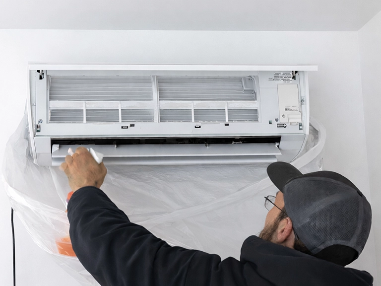 Worker cleaning heat pump